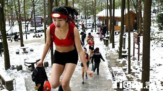 张家界别样登山赛 选手夏装短裤雪天爬山